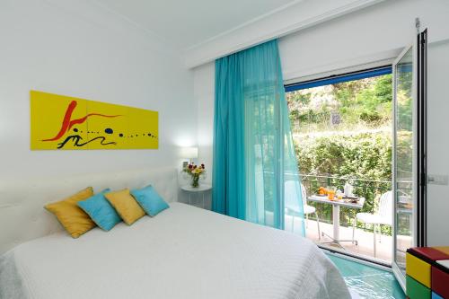 1 dormitorio con cama y ventana grande en Amalfia Apartments, en Amalfi