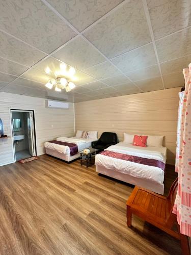a room with two beds and a chair in it at Taroko Little Fish in Xincheng