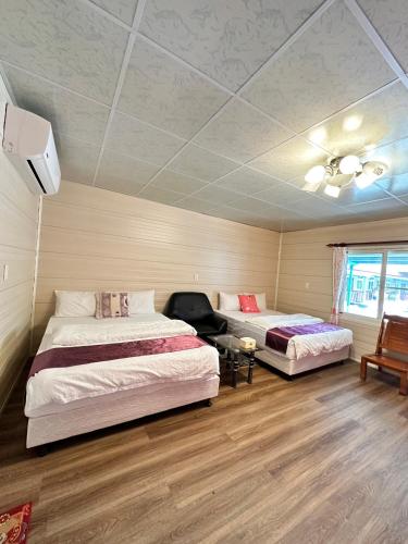 a bedroom with two beds and a ceiling at Taroko Little Fish in Xincheng