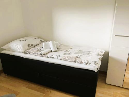 Bett mit schwarzem Rahmen und weißer Bettwäsche in der Unterkunft Apartment River in Bratunac
