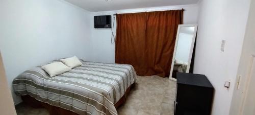 Dormitorio pequeño con cama y espejo en Departamento Cómodo Corrientes Capital en Corrientes