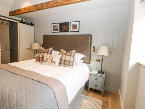 a bedroom with a large white bed with pillows at Brampton in Appleby