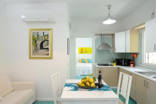 een keuken met een tafel en een fruitschaal bij Amalfia Apartments in Amalfi