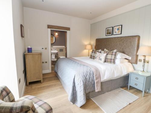 a bedroom with a large bed and a chair at Bolton in Appleby