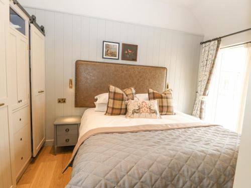 a bedroom with a large bed with pillows at Hilton Cottage in Appleby