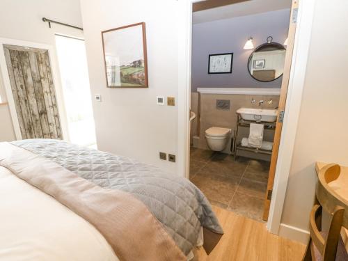 ein Schlafzimmer mit einem Bett und ein Badezimmer mit einem Waschbecken in der Unterkunft Marton in Appleby