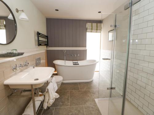 艾波比的住宿－Murton Cottage，带浴缸、水槽和淋浴的浴室