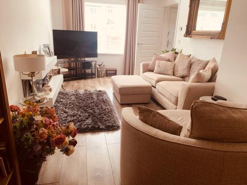 a living room with a couch and a tv at Home from home - Free Parking (near Edinburgh / Airport and Ingilston) in Edinburgh