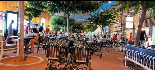 a group of people sitting at tables in a restaurant at Athens Villa Artemis pool Sea Airport in Artemida