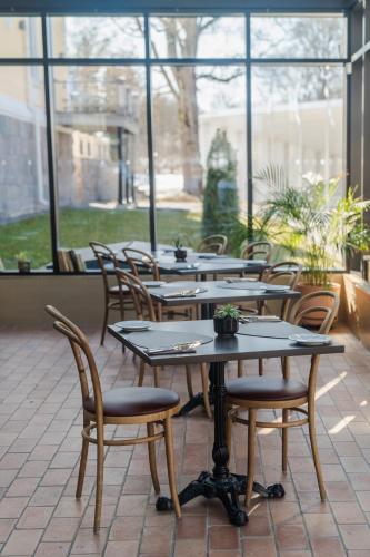 a row of tables and chairs in a room with windows at Schloss Fellin Boutique Hotel and Spa in Viljandi