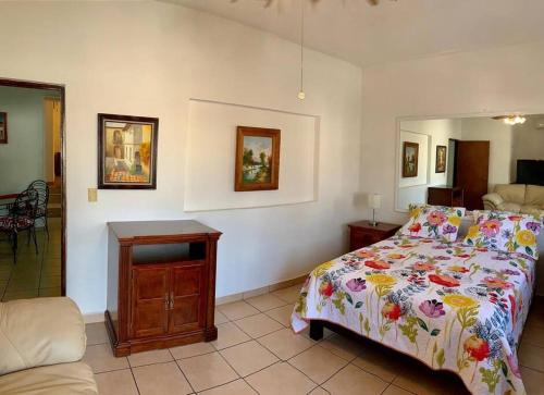 Casa Galerias Vicario (apartment) في بويرتو فايارتا: غرفة نوم مع سرير مع لحاف مزهر