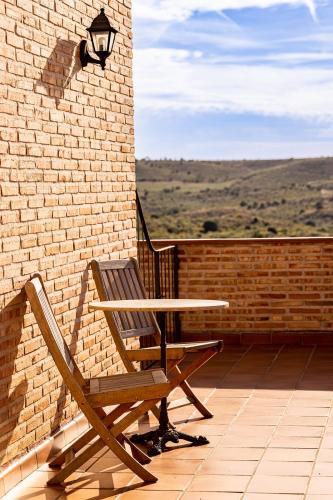 a table and a chair sitting on a patio at CASA RURAL Cigarral del Pintor in Toledo