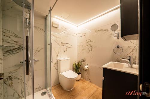 a bathroom with a shower and a toilet and a sink at Spinola Stays St Julian's in St. Julianʼs