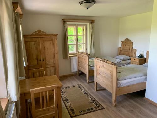 a bedroom with two beds and a table and a window at Na Vyhlídce in Krompach