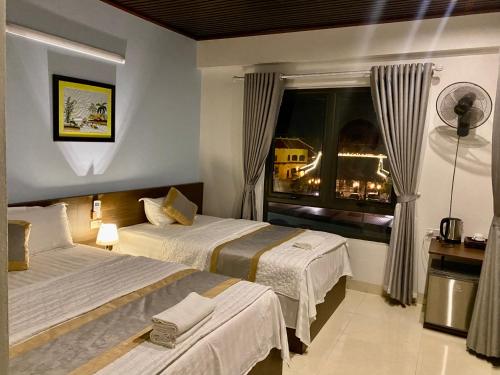 a hotel room with two beds and a window at Tam Coc Elegance House in Ninh Binh