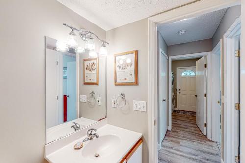 ein weißes Badezimmer mit einem Waschbecken und einem Spiegel in der Unterkunft Cubs Crossing in Glen Arbor