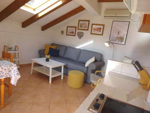 a living room with a blue couch and a table at Eco Apartments Kate in Suđurađ