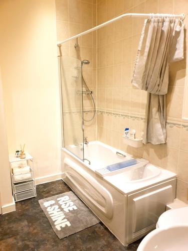 a bathroom with a shower and a tub and a toilet at Platinum Apartment Birmingham- Free Secure Parking- Fast Fibre Wi-Fi in Birmingham