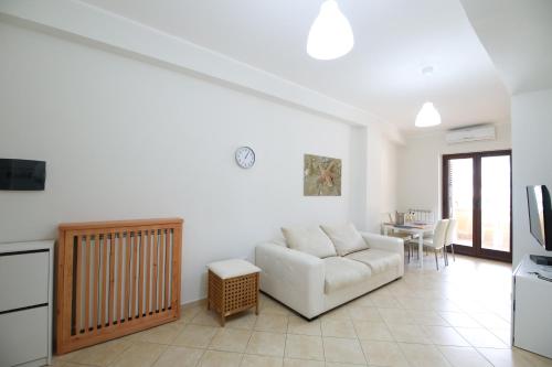 - un salon avec un canapé blanc et une table dans l'établissement Costabella Apartment Tropea, à Tropea