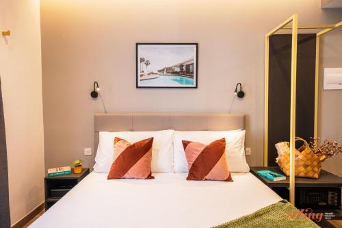 a bedroom with a bed with white sheets and orange pillows at Spinola Stays in St. Julianʼs