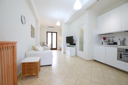un soggiorno con divano bianco e una cucina di Costabella Apartment Tropea a Tropea