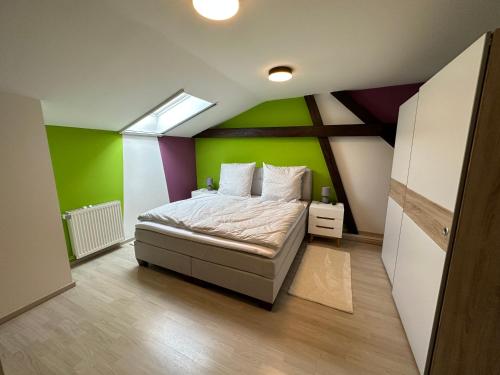 1 dormitorio con 1 cama con pared verde en Ferienwohnung am Schutzgraben, en Lübben