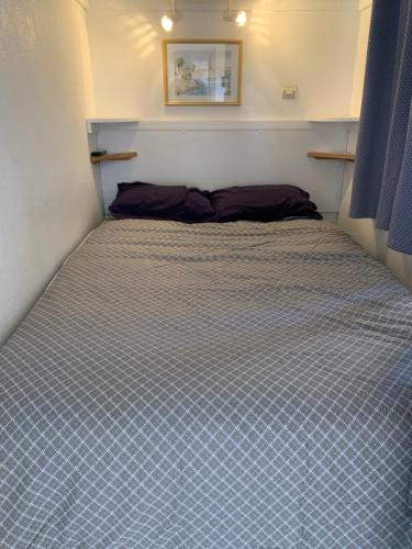 uma cama num pequeno quarto com um espectáculos de roupa de cama em Appartement Village Vacances Cap Esterel em Saint-Raphaël