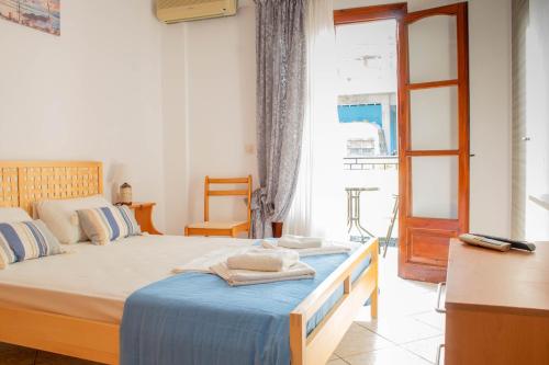 a bedroom with a large bed with a blue blanket at Alexandra's House in Skiathos