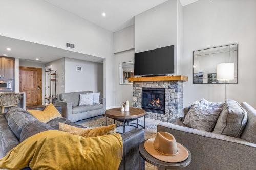 a living room with a couch and a fireplace at BRAND NEW - Gorgeous Spring Creek Penthouse in Canmore