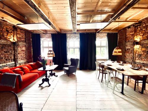 パシムにあるLoft with Lake View Pasym Koneserのリビングルーム(赤いソファ、テーブル、椅子付)