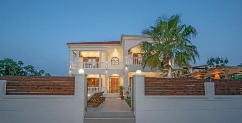 una grande casa bianca con una recinzione di Estella Luxury Villa in Amoudi -200m from the beach ad Amoudi