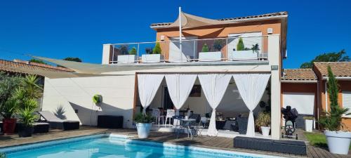 a villa with a swimming pool and a house at Chambre Gaëlle et Brian in Cardet