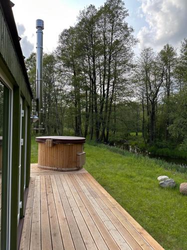 a wooden deck with a hot tub on the side of a house at ALANTOS ŽIRGAI Holiday Villas sauna or hottube additional price in Alanta
