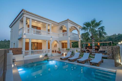 a villa with a swimming pool and a house at Estella Luxury Villa in Amoudi -200m from the beach in Amoudi