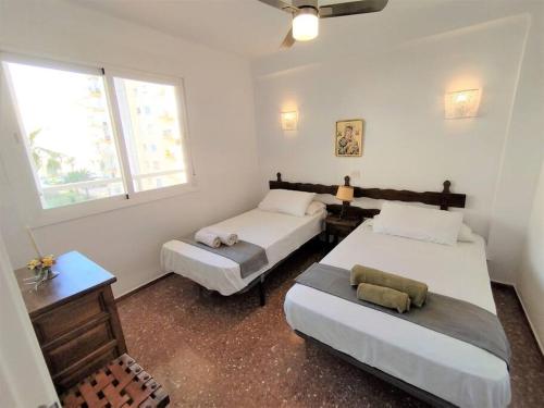 una camera con due letti e un tavolo e due finestre di Beachfront apartment ALG-Costa a Algarrobo-Costa