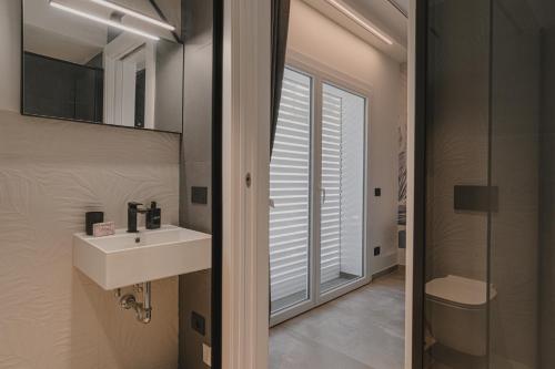 a bathroom with a sink and a glass door at VillaLume in Marina di Castagneto Carducci