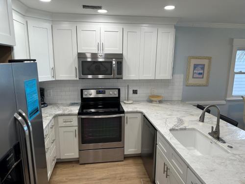 a kitchen with white cabinets and stainless steel appliances at Boston Commons 102 Condo in Myrtle Beach