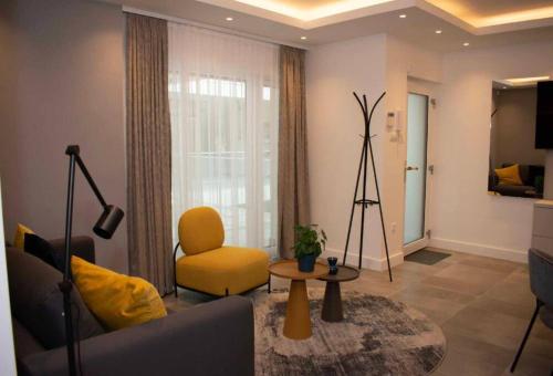 ein Wohnzimmer mit einem Sofa und einem gelben Stuhl in der Unterkunft Luxury Cozy 2 BDR Downtown Apt.3 in Budapest