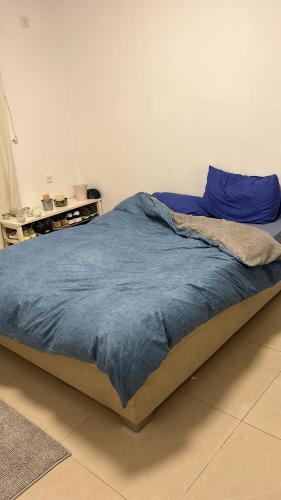 a bed with a blue blanket on top of it at Apartment near Hilton in Tel Aviv