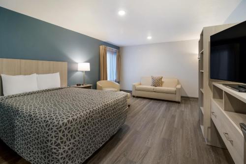 ein Hotelzimmer mit einem Bett und einem Flachbild-TV in der Unterkunft WoodSpring Suites Hermitage - Nashville Airport in Hermitage