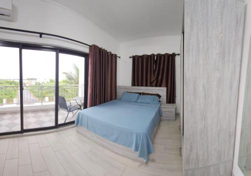 a bedroom with a blue bed and a balcony at 3 Bedroom Family Pool Villa Flic-en-Flac Beach in Flic-en-Flac
