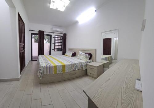 a bedroom with a bed and a table in it at 3 Bedroom Family Pool Villa Flic-en-Flac Beach in Flic-en-Flac