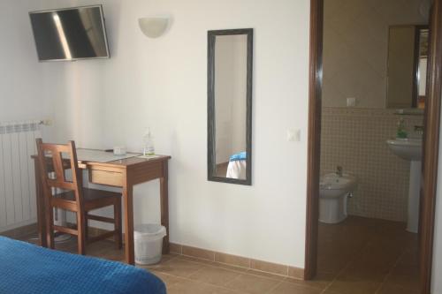 1 dormitorio con mesa y baño con lavamanos en Rustic Villa Guesthouse, en Santa Bárbara de Nexe