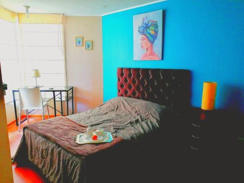 een slaapkamer met een bed en een blauwe muur bij Flat next to the ocean. Tower E in Lima