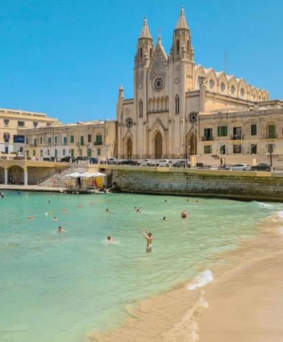 a group of people in the water in front of a building at Ewa Apt - 3-Bedrooms Apt near Sliema - St Julians Seafront in Il-Gżira