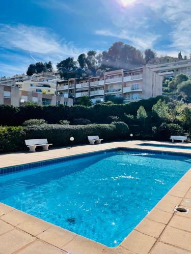une piscine devant un immeuble dans l'établissement Studio Cosy avec terrasse et Garage Saint-Laurent du Var limitrophe Nice, à Saint-Laurent-du-Var