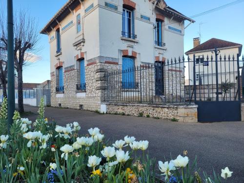 a house with blue windows and flowers in front of it at Appartements de Diane - JOIGNY in Joigny