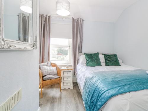 a bedroom with two beds and a chair and a window at Donnys Plaice in Great Yarmouth