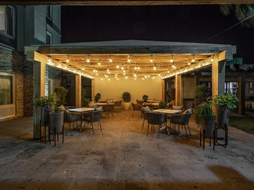 a patio with tables and chairs and lights at Hotel Mesaluna Near American Consulate in Ciudad Juárez