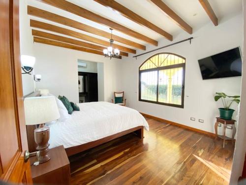 Un dormitorio con una gran cama blanca y una ventana en Mountaintop Luxury Estate - Can Sleep up to 24!, en Macacona